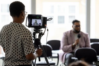 Student in University Libraries operating a camera at a Tech for Humanity Summit